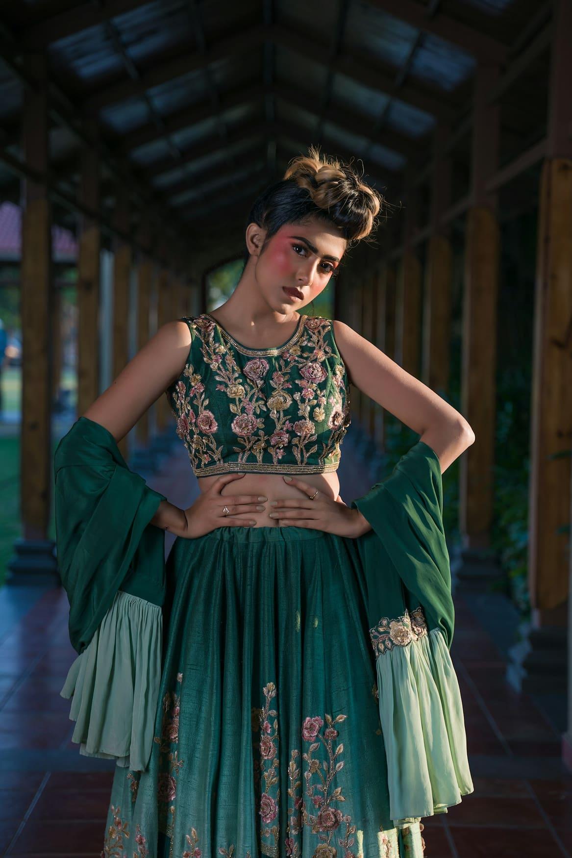 Woman in an emerald green embroidered lehenga choli