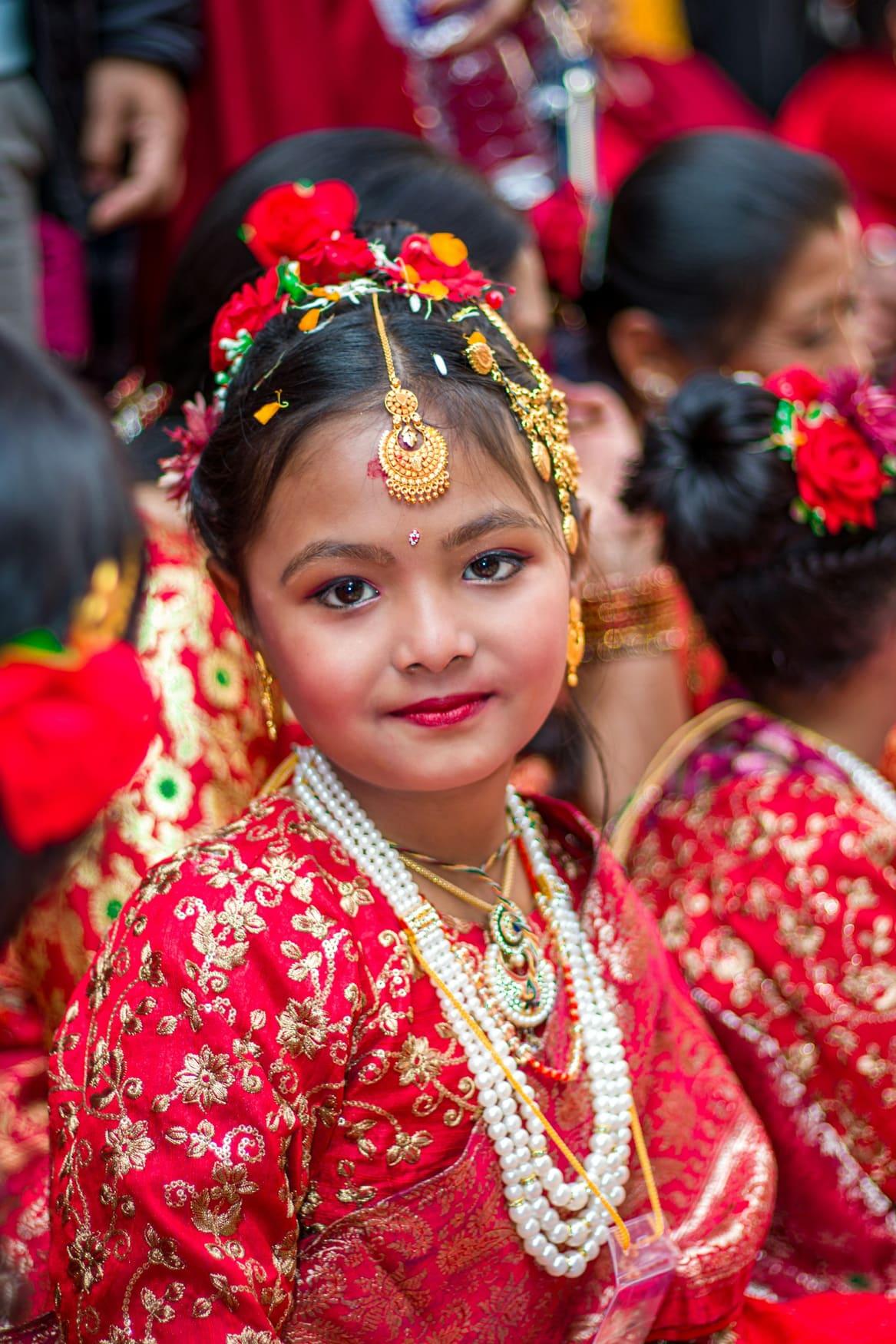 Little girl in a red brocade festive outfit with traditional jewellery