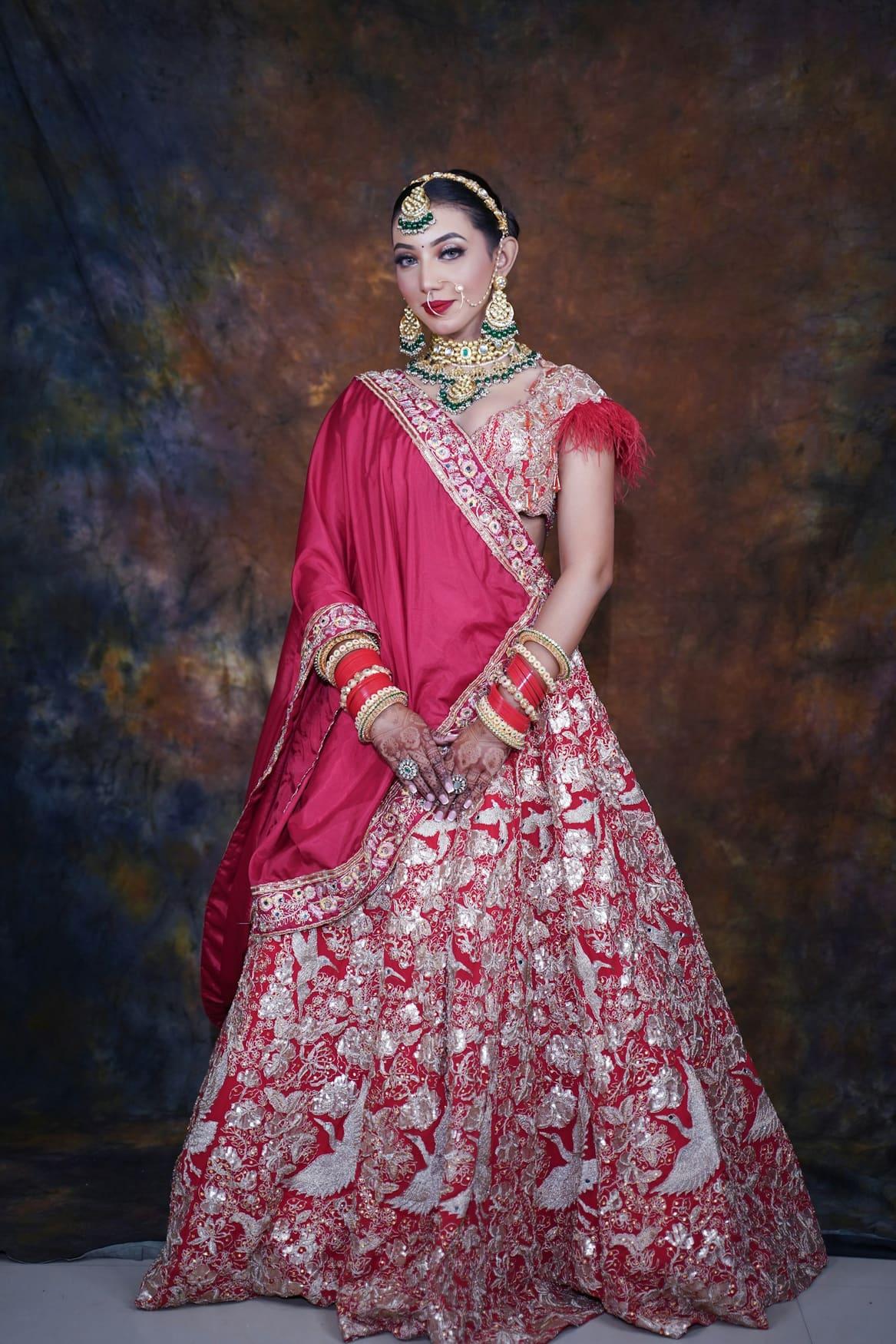 Bride in a rani pink lehenga with gold zardozi embroidery and kundan jewellery